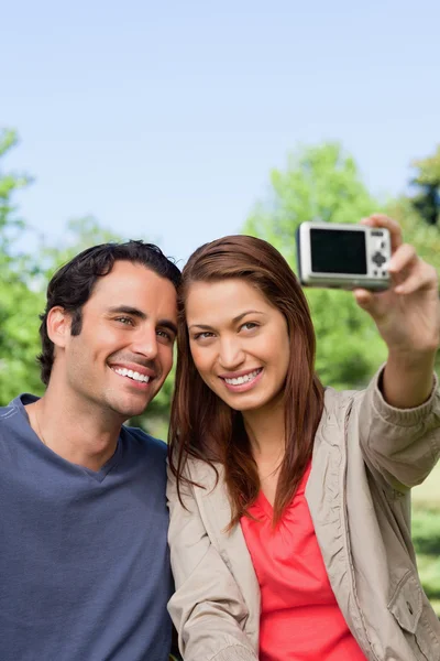 Vrouw en haar vriend kijken naar haar camera voor een beeld van — Stockfoto