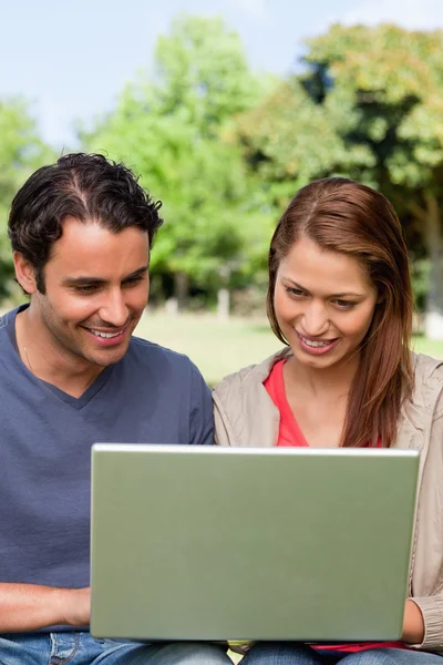 Dois amigos sorrindo enquanto assistem algo em um tablet — Fotografia de Stock