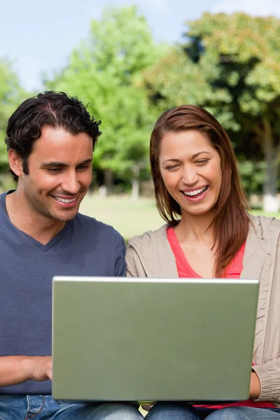 Dois amigos rindo enquanto assistem algo em um tablet — Fotografia de Stock