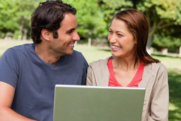 Two friends smiling as they look at each other while holding a t — Stock Photo, Image