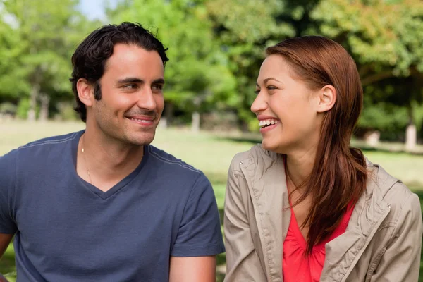 Man is grinning while he watches his friend who is laughing — Stock Photo, Image