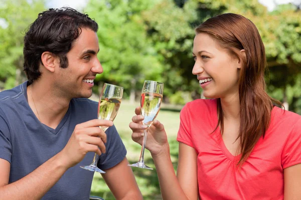 Two friends looking at each other while they are holding glasses — Stock Photo, Image