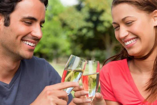 Dois amigos sorrindo enquanto tocam copos de champanhe juntos — Fotografia de Stock
