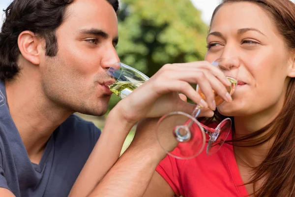 Два друга связывают руки, когда пьют шампанское. — стоковое фото