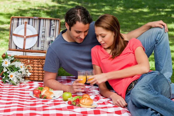 Zwei Freunde, die beim Picknick Gläser gegeneinander anfassen — Stockfoto