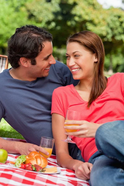 Two friends smiling each other while they hold glasses as they — Stock Photo, Image