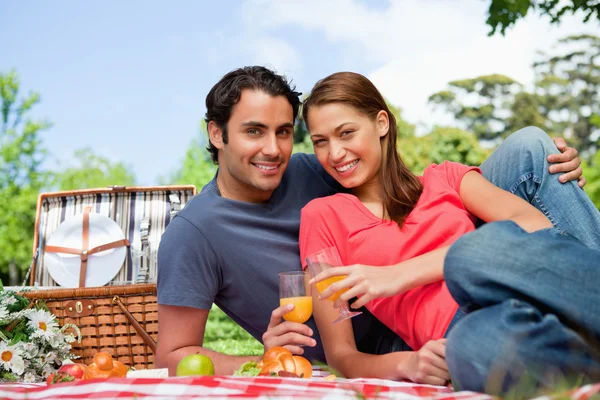 Two friends looking ahead while they hold glasses during a picni — Stock Photo, Image