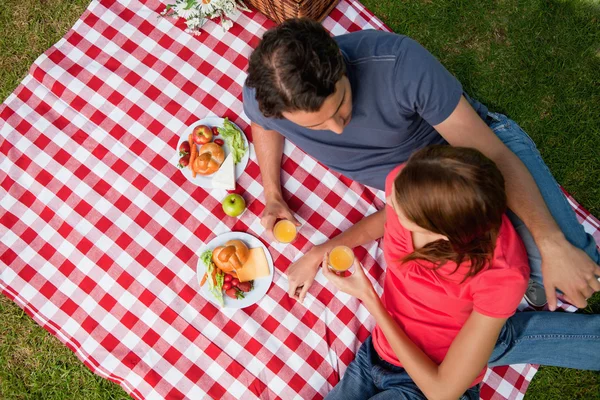 Erhöhter Blick auf zwei Freunde, die mit einem Picknick auf einer Decke liegen — Stockfoto