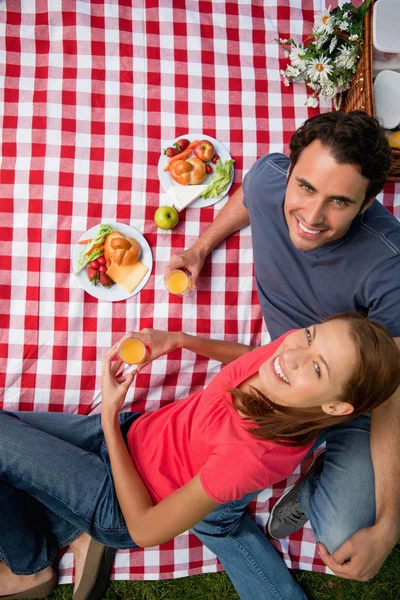 Elevated view of two smiling friends as they lie on a blanket wi — Stock Photo, Image