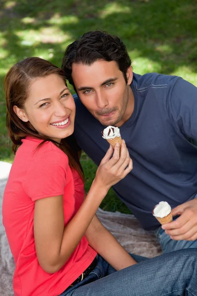 Two smiling friends looking upwards while holding ice cream — Stock Photo, Image