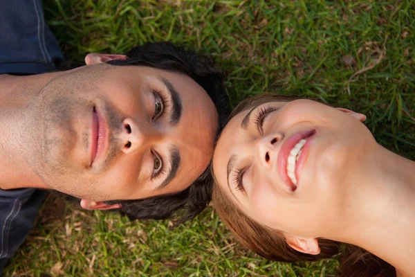 Primer plano de dos amigos mirándose mientras están tumbados cabeza t —  Fotos de Stock