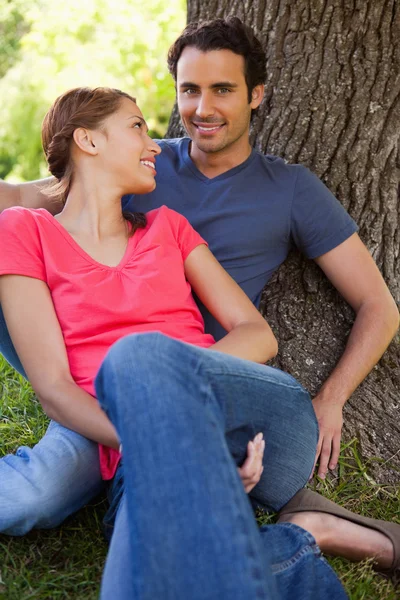 Woman looking at her friend while they sit together in the shade — Stock Photo, Image