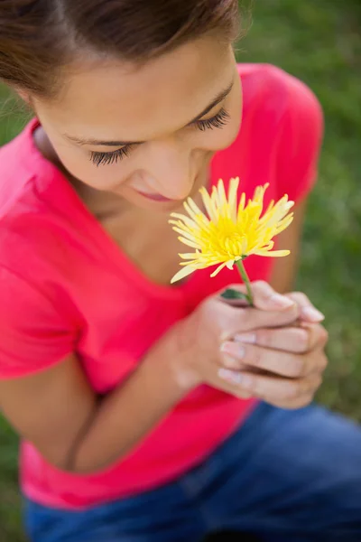 Mulher cheirando uma flor amarela — Fotografia de Stock