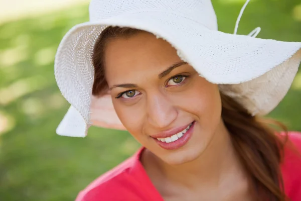 Donna sorridente mentre indossa un cappello bianco — Foto Stock