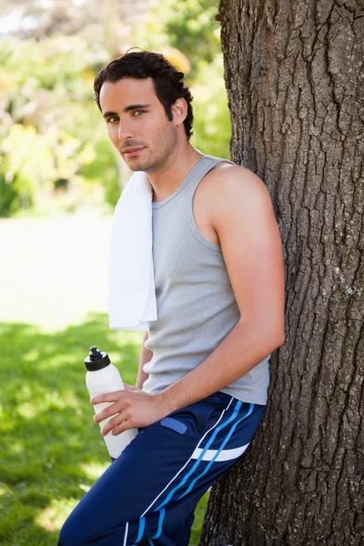 Adam bir spor şişe tutan ve restin ise yan bakan — Stok fotoğraf