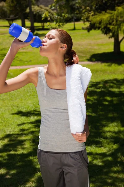 Mujer bebiendo de una botella deportiva — Foto de Stock