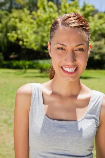 Woman smiling while looking straight ahead — Stock Photo, Image