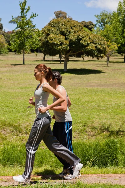 Donna e un uomo che fanno jogging fianco a fianco — Foto Stock