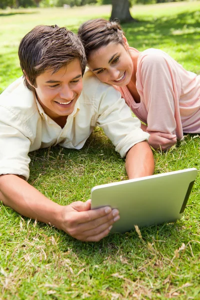 Vrouw leunt tegen haar vriend als ze samen een Tablet PC gebruiken — Stockfoto