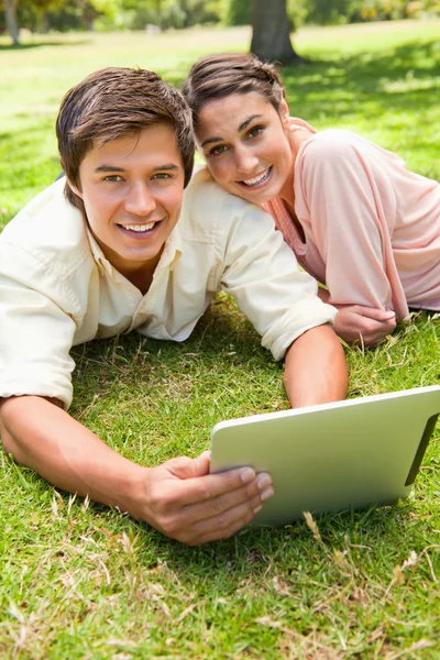 Two friends looking ahead as they use a tablet together — Stock Photo, Image