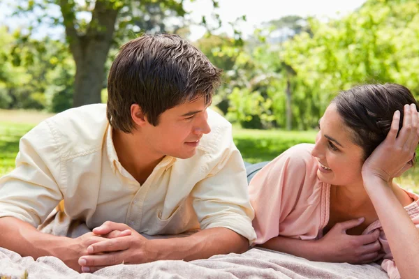 Deux amis se regardent alors qu'ils sont allongés sur une couverture grise — Photo