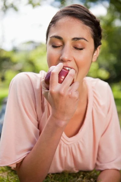 Woman biting into an apple — Stock Photo, Image