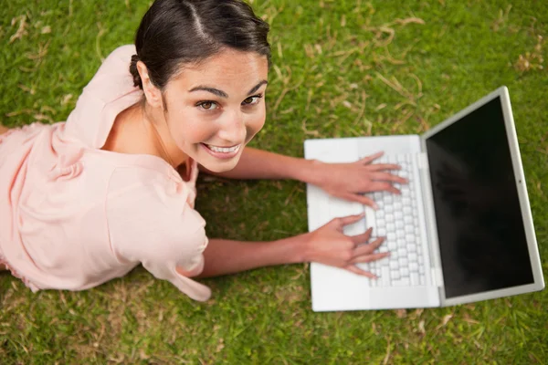 Mujer mirando hacia arriba mientras usa el ordenador portátil —  Fotos de Stock
