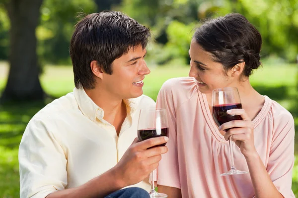 Zwei Freunde schauen einander an, während sie Weingläser halten — Stockfoto