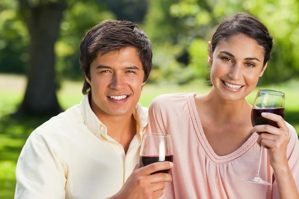 Dois amigos olhando para a frente enquanto segurando copos de vinho — Fotografia de Stock