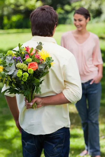 Homem prestes a surpreender seu amigo com um buquê de flores — Fotografia de Stock