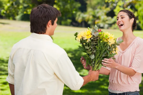 Uomo presenta il suo amico con fiori — Foto Stock