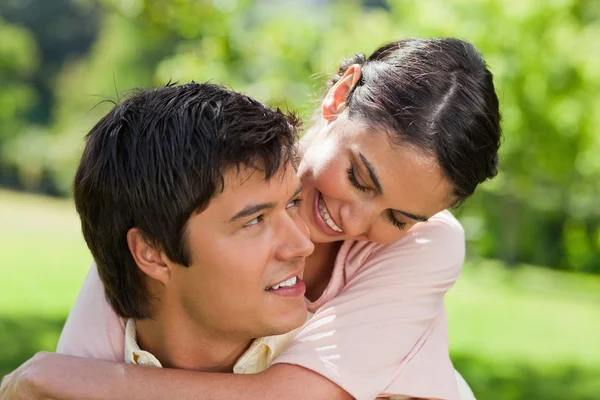 Woman looking at her friend while he is carrying her — Stock Photo, Image