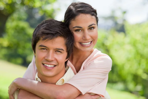 Frau lächelt mit ihrem Freund, der sie trägt — Stockfoto