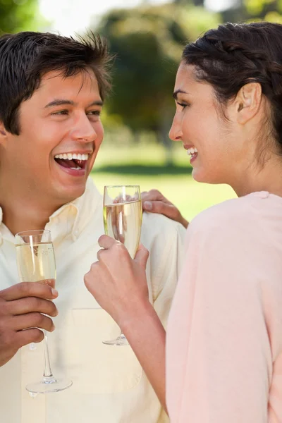 Dos amigos riendo mientras sostienen copas de champán —  Fotos de Stock
