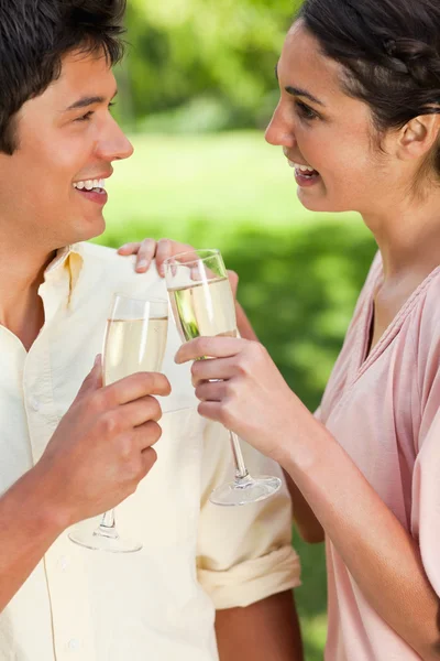 Two friends looking at each other while touching glasses of cham — Stock Photo, Image