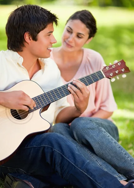 Homem sorrindo enquanto tocava guitarra enquanto ele está sendo assistido b — Fotografia de Stock