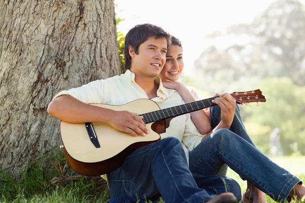 Man playing the guitar while looking into the distance with his — Stock Photo, Image