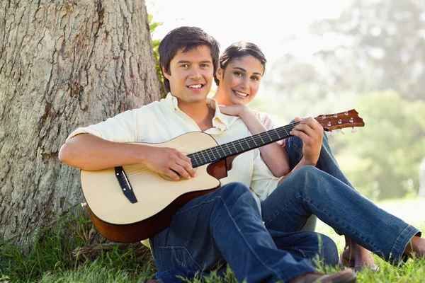 Muž hraje na kytaru vpřed se svým přítelem — Stock fotografie