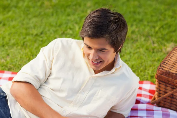 Mannen leende som han Ligg på en picknick-filt — Stockfoto