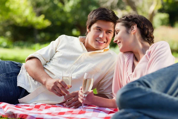 Uomo sorridente mentre guarda il suo amico durante un picnic — Foto Stock