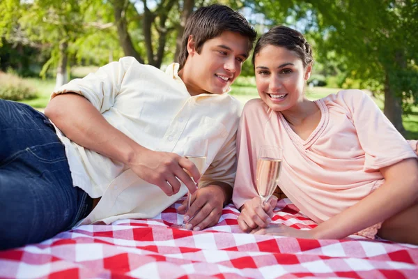 Man kijken naar zijn vriend terwijl aangezien zij gaan op een deken liggen wh — Stockfoto