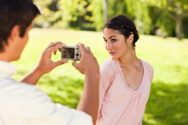 L'homme prend une photo de son ami pendant qu'elle pose — Photo