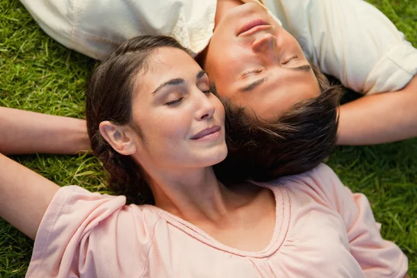 L'homme et une femme couchés tête contre épaule avec leur bras derrière le — Photo