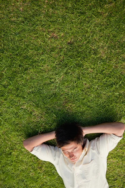 Elevated view of a man lying with his eyes closed and his head r — Stock Photo, Image