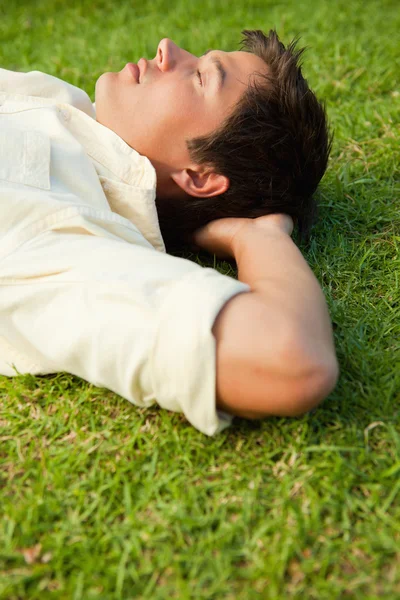 Vista lateral de un hombre acostado con los ojos cerrados y la cabeza descansada —  Fotos de Stock