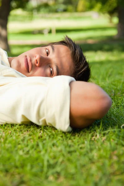 Hombre con expresión seria acostado con el lado de su cabeza en reposo —  Fotos de Stock