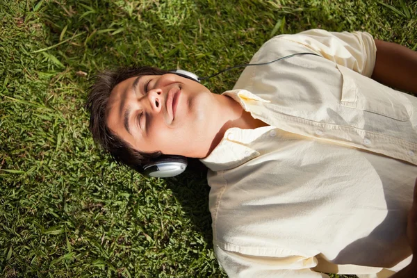 Człowiek z jego oczy zamknięte podczas korzystania z słuchawki słuchać mus — Zdjęcie stockowe