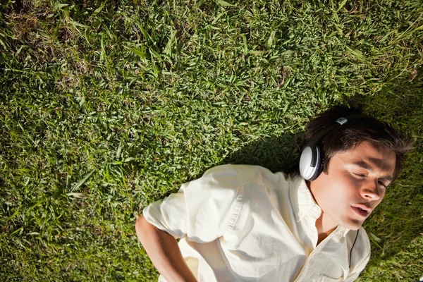 Bir adamın müzik dinlemek için kulaklık kullanarak yükseltilmiş görünümü — Stok fotoğraf