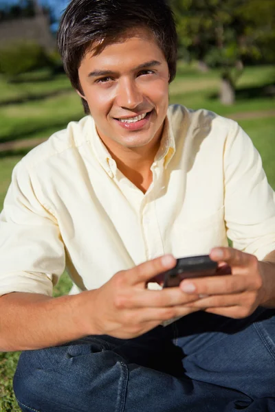 Man looking ahead while writing a text message as he is sitting — Stock Photo, Image