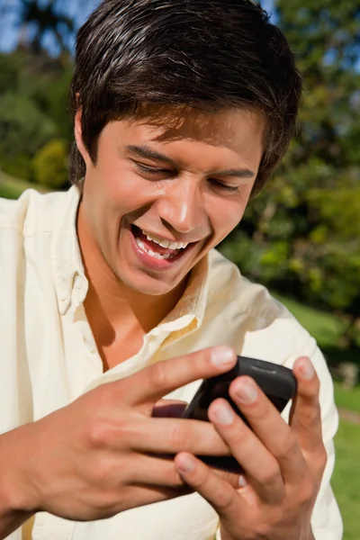 Close-up of a man using a phone while he is sitting down — Stock Photo, Image